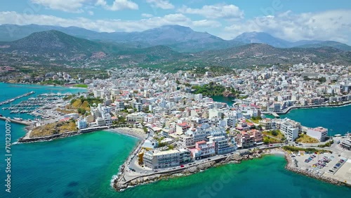 Aerial panoramic view of Agios Nikolaos City on Crete Island in Greece in 4K. Sunny summer City day on Mediterranean Island with turquoise water. Paralia Kitroplatia, Ammos, Yachting Sailing Cruises