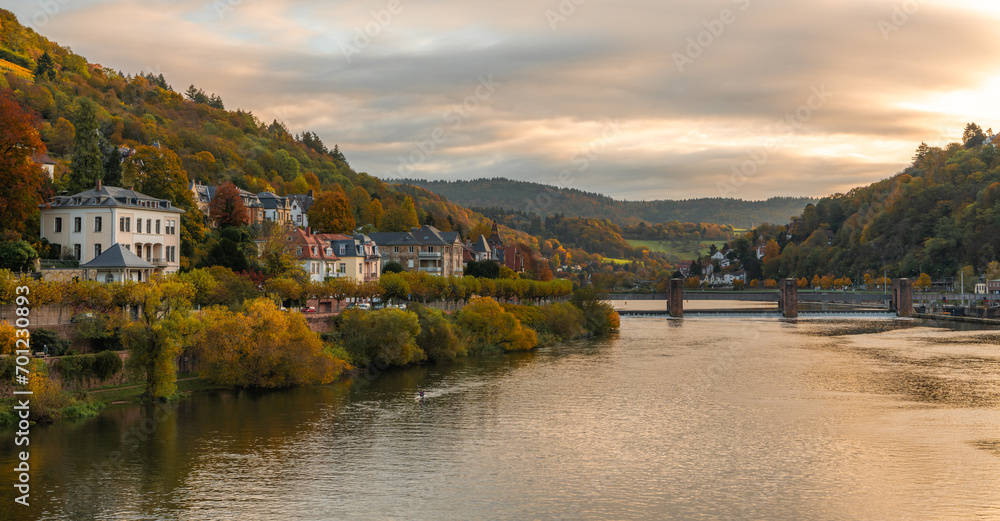 Beautiful morning view with warm colors on the riverbanks of the Neckar river. Beautiful historical city of Heidelberg in Germany.
