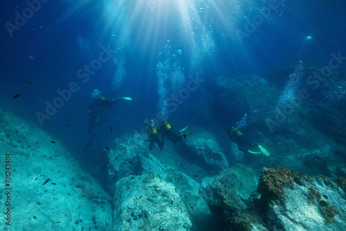 Scuba diving, scuba divers with sunlight and bubbles underwater in the Mediterranean sea, France, Occitanie