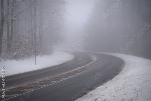 Bad weather driving - foggy hazy country road. Motorway - road traffic. Winter time. Autumn - fall. Snow and frost on the road in winter.