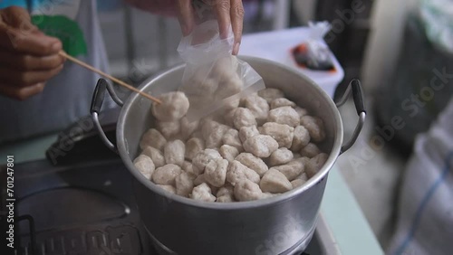 boil meatballs. close-up view, meatball seller serving buyers, 4K video of indonesian street food photo