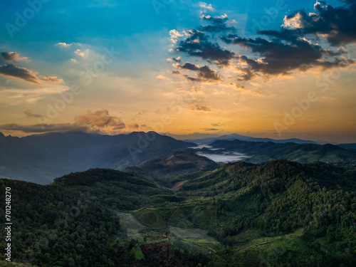 Panorama of sunrise on the mountains, Beautiful landscape with hills and mountains with knee timber and yellow grass and valleys filled with mist lightened with warm sunrise light.