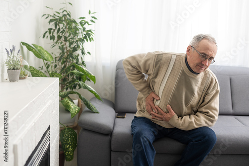 Senior man having stomach pain sitting at home. © Angelov