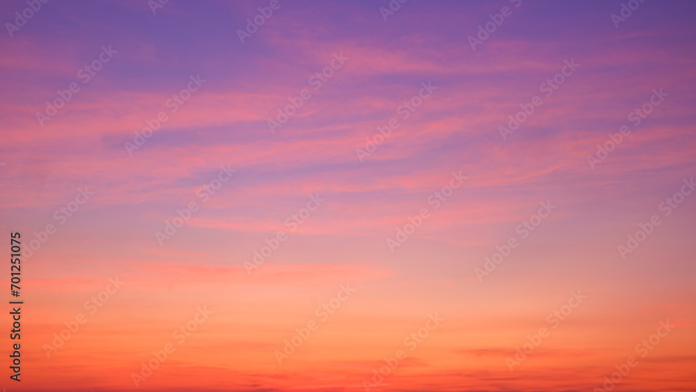 Sunset sky background with beautiful pink sunset clouds on colorful yellow, orange, and blue purple sunlight on romantic evening twilight sky