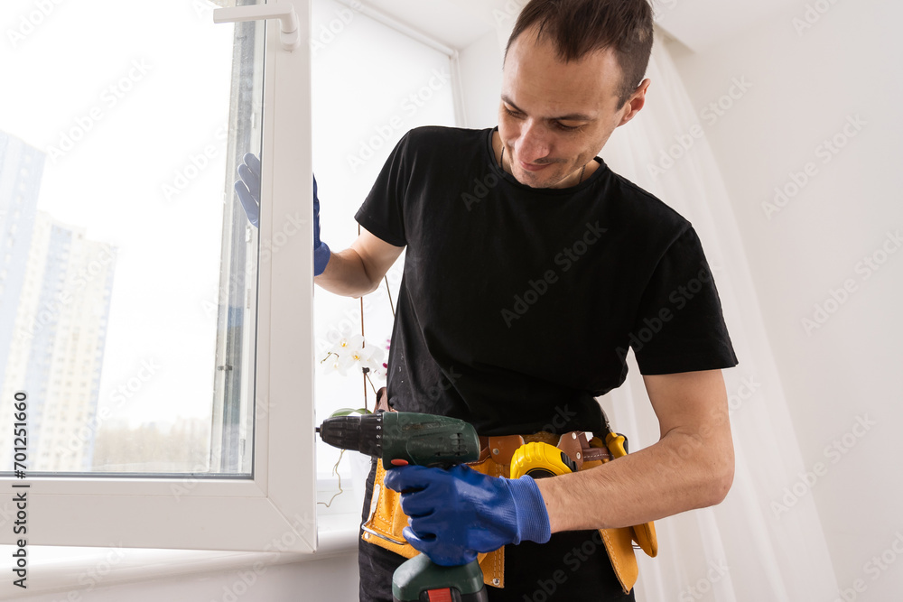 A handsome young man installing Double Sliding Patio Door in a new house construction site A handsome young man installing Double Sliding Patio Door in a new house construction site