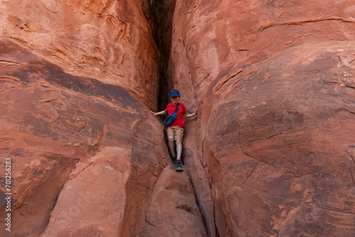 Boy Climbing Rocks in Arches National Park, Utah