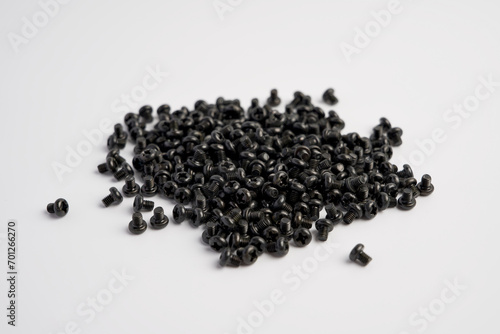 White background with a handful of small black screws
