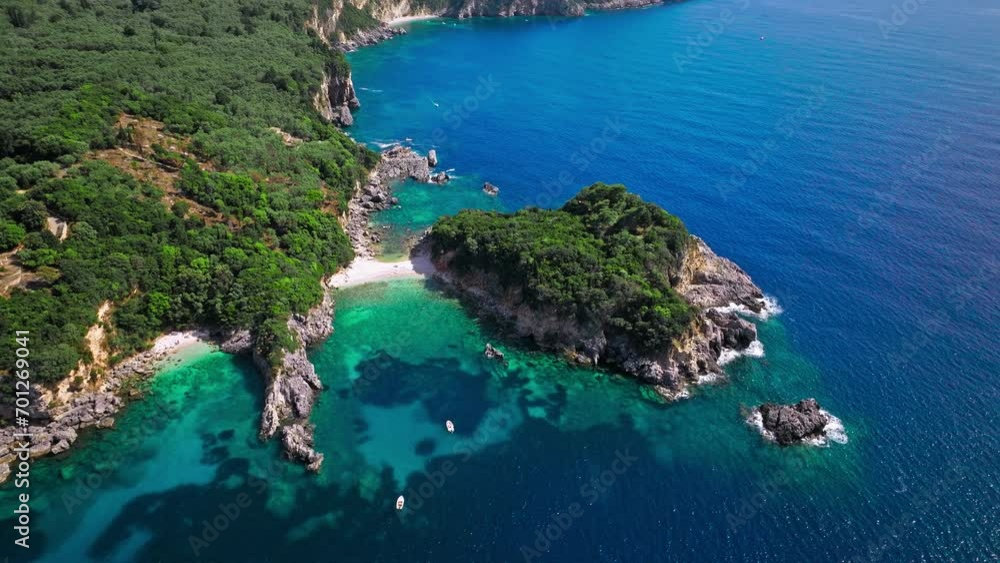 Aerial view of Limni Beach Glyko with dreamy crystal-clear turquoise waters by the rocky cliffs. View of mesmerizing white-pebble shore mixed with sand and green forest in Corfu, Greece. Aerial view of Limni Beach Glyko with dreamy crystal-clear turquoise waters by the rocky cliffs. View of mesmerizing white-pebble shore mixed with sand and green forest in Corfu, Greece.