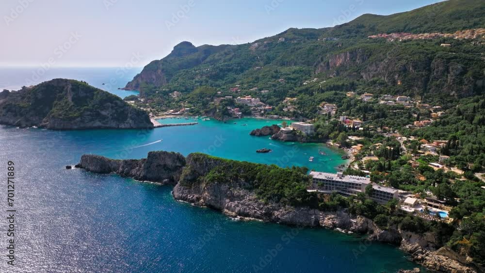 Aerial view of Limni Beach Glyko with dreamy crystal-clear turquoise waters by the rocky cliffs. View of mesmerizing white-pebble shore mixed with sand and green forest in Corfu, Greece. Aerial view of Limni Beach Glyko with dreamy crystal-clear turquoise waters by the rocky cliffs. View of mesmerizing white-pebble shore mixed with sand and green forest in Corfu, Greece.