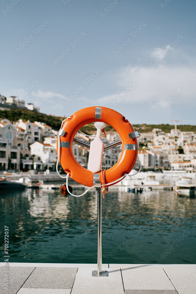 Lifebuoy on a stand with a latch stands on the shore of Lustica Bay. Montenegro