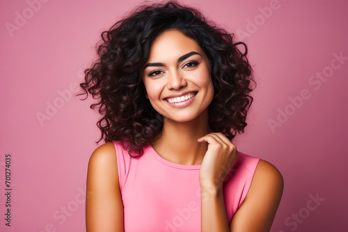 Woman with curly hair smiling and posing for picture.
