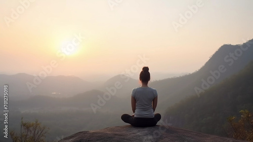 Back of healthy women practicing yoga meditation in sitting pose with mountains and sunrise background