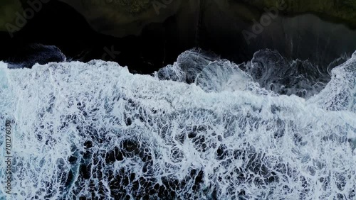 Play of waves on a black sand beach