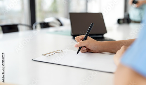Crop shot of person with pen signing contract at desk photo
