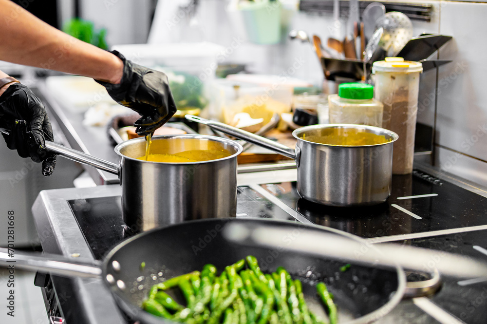Chef hands cooking cheese sauce in the restaurant kitchen Chef hands cooking cheese sauce in the restaurant kitchen