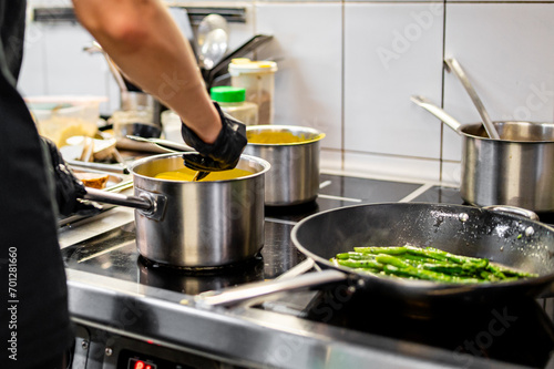 Chef hands cooking cheese sauce in the restaurant kitchen photo