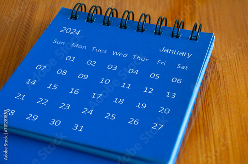 January 2024 table calendar on wooden desk. Time and calendar concept