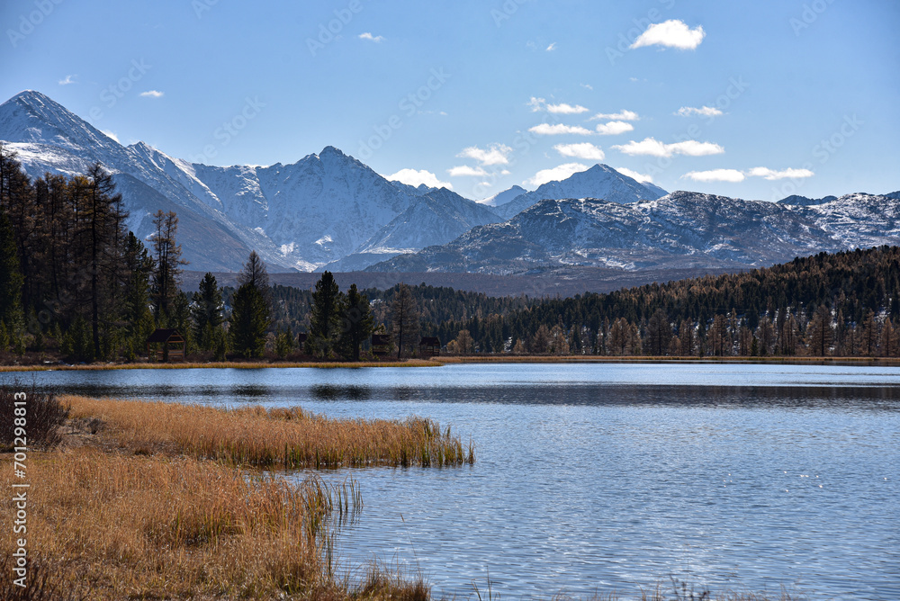 Mountain landscape. Mountain lake in autumn against the backdrop of snowy peaks.