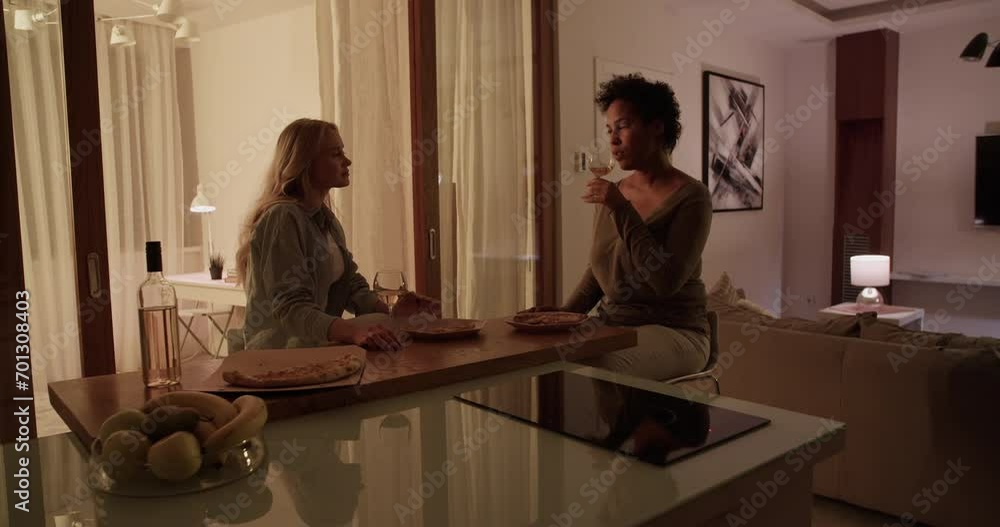 Diverse girlfriends drinking wine and eating pizza Diverse girlfriends drinking wine and eating pizza