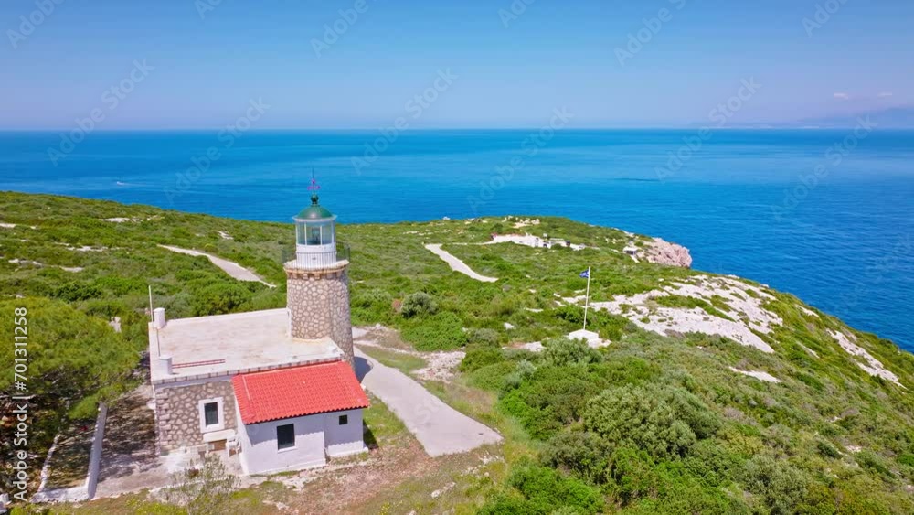 Aerial view of Skinari Lighthouse stone-built round tower in Zakynthos. Greek architecture, tower rising from a keeper's house, and a greek flag in Zante, Greece. Aerial view of Skinari Lighthouse stone-built round tower in Zakynthos. Greek architecture, tower rising from a keeper's house, and a greek flag in Zante, Greece.