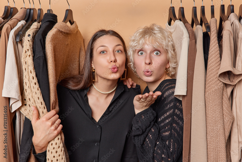 Horizontal shot of two young women blow air kiss and have romantic ...