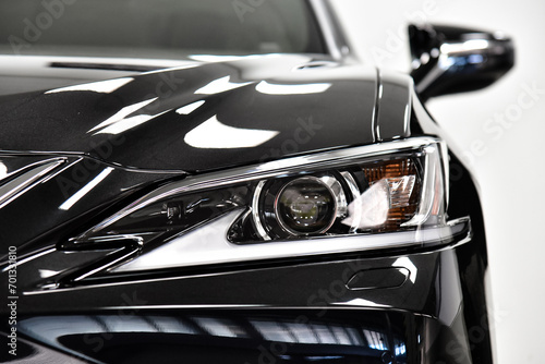 Front headlight of a black car. Close-up.