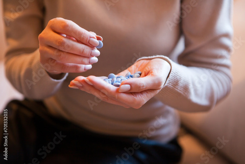 pills in young woman hand. Female hand sorting pills on brown background