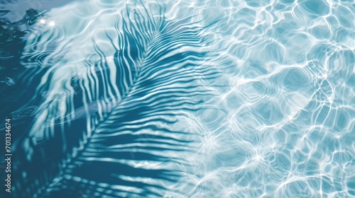 palm leaf shadow on blue water waves, vacation and beauty care with copy space photo