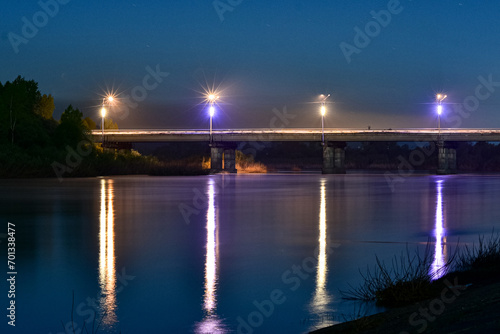 Night landscape. Road bridge over the river at night.