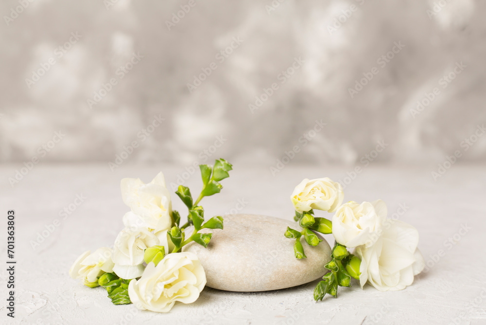 Stone podium with freesia flower on concrete background. Mock up for cosmetic products Stone podium with freesia flower on concrete background. Mock up for cosmetic products