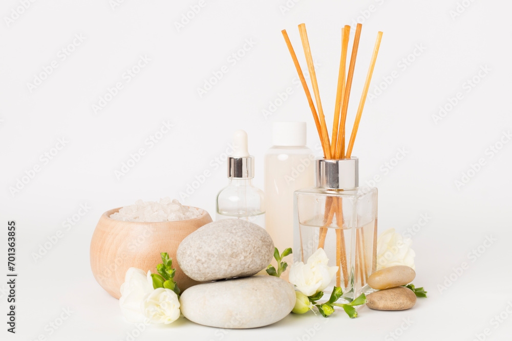 Spa composition with freesia flower and aroma diffuser on white background Spa composition with freesia flower and aroma diffuser on white background