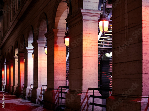Colonnes illuminées en couleur d'un monument d'architecture ancien dans le centre ville historique. Arcades de circulatiion avec lanternes vintages de nuit. photo