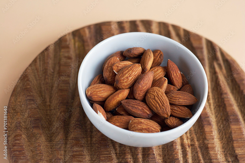 Almonds in a bowl on a wooden board Almonds in a bowl on a wooden board