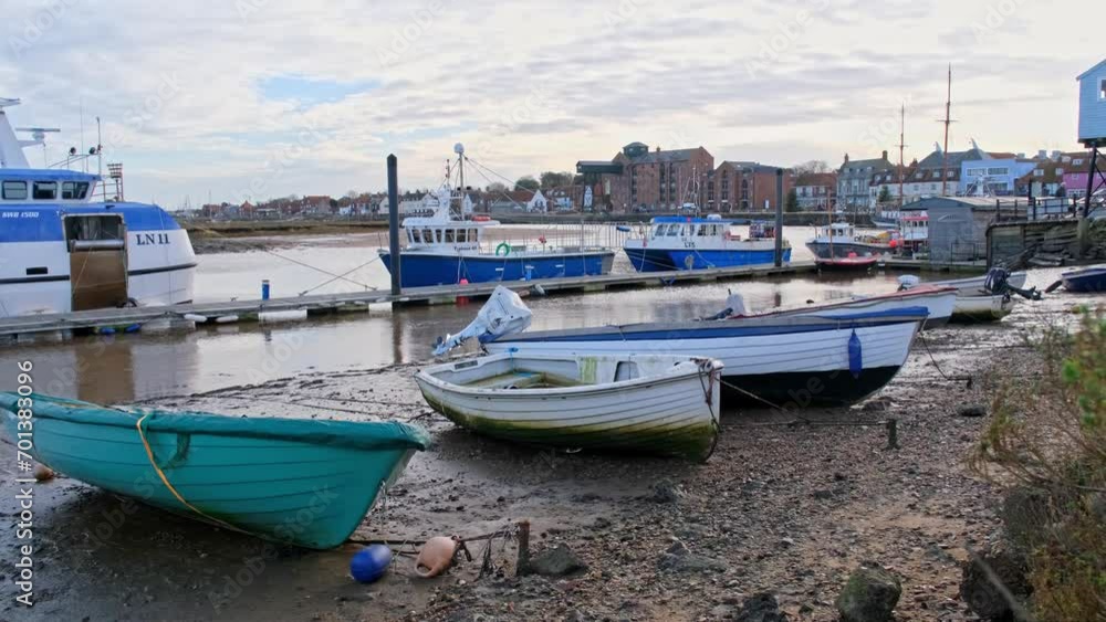 View across the boats moored in the harbour at low tide and towards the town View across the boats moored in the harbour at low tide and towards the town