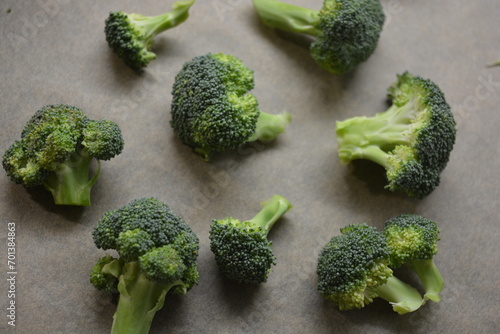 Healthy, wholesome, high-quality food, fresh vegetables, pieces of green broccoli arranged on brown parchment paper.