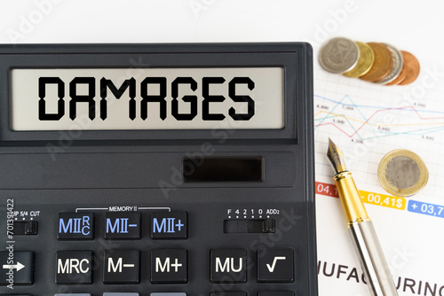 On the table are financial reports, coins and a calculator with the inscription - damages photo