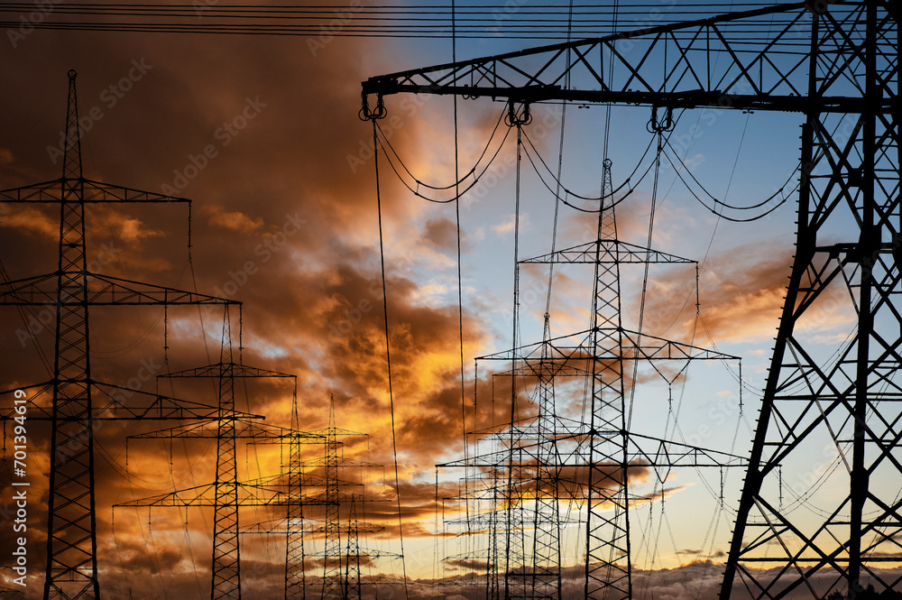 high voltage electric poles against sky with dramatic clouds