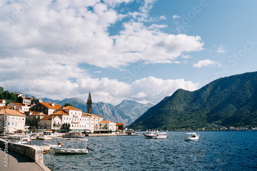 Many excursion boats with canopies are moored off the coast of Perast with views of the mountains. Montenegro
