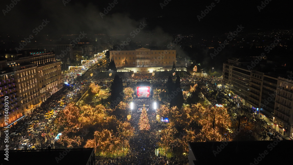 Fototapeta premium Aerial drone night shot of illuminated iconic Syntagma square at new year's eve celebration with fireworks welcoming 2024, Athens, Attica, Greece