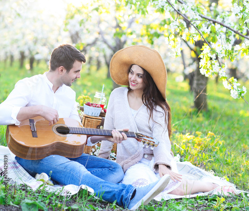 Young couple in love at picnic in spring blossom garden