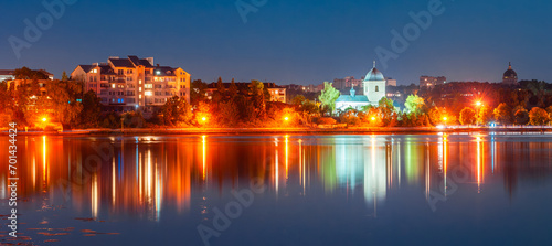 Panorama of the night city with the rays of lanterns and a beautiful reflection in the water. Ternopil, Ukraine photo