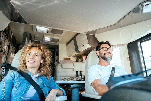 Man driving camper smiles while driving with his wife company. Concept of travel, vacation and life together