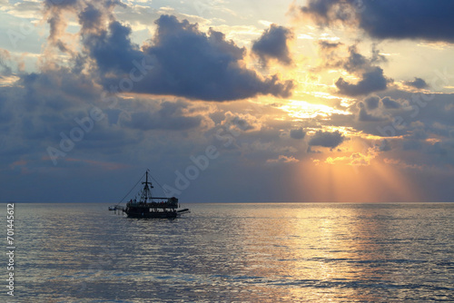 Sea sunset Ship. Blue Sea silhouette of the ship on the horizon. Sunset on the Ocean coast. Beautiful Seascape. Boat and sun reflection on the water. Beautiful sea at sunset. Ocean and sky background 