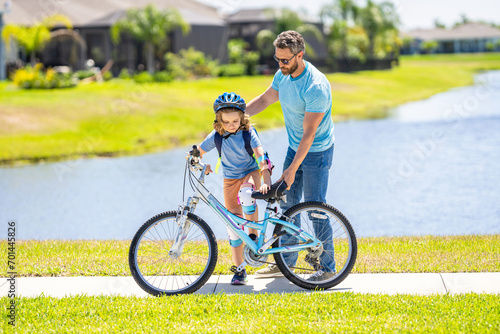 dad and son duo pedaling through picturesque landscape. supportive dad guiding his son first bike ride. dad and son enjoying fun bike outing. dad and son on biking adventure. family relationship