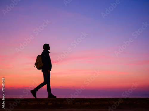 Fototapeta Naklejka Na Ścianę i Meble -  Woman tourist against colorful sunset sky. Travel, tourism concept. Active lifestyle.