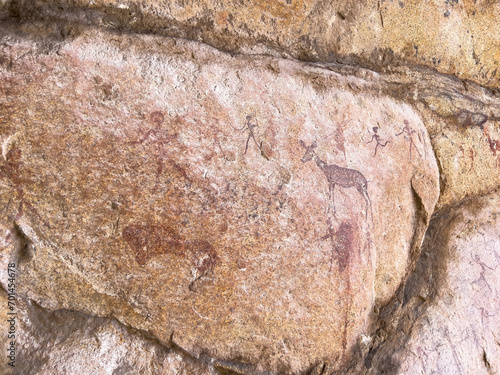 Erongo mountains, Namibia - August 16, 2022: Ancient rock art depicting figures and animals in reddish pigment on a stone surface, showcasing the prehistoric artistry and storytelling photo
