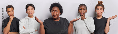 Image of hesitant overweight curly African American woman spreads palms feels confused spreads palms poses between people of different race isolated over white background. Who cares I dont know
