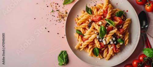 Pasta with eggplant tomato sauce basil served with grated ricotta salata cheese Pasta alla Norma pasta salad Pink and beige table surface Directly above vertical image. Creative Banner photo