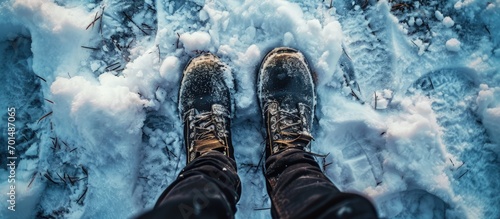 Man in black pants and winter boots standing in the snow outdoors close up Top view first person view. Creative Banner. Copyspace image