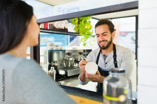 Cheerful worker taking the coffee order of a customer